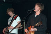 Bass guitarist (John Reynolds) and lead vocalist (Dominic James) playing guitar and singing